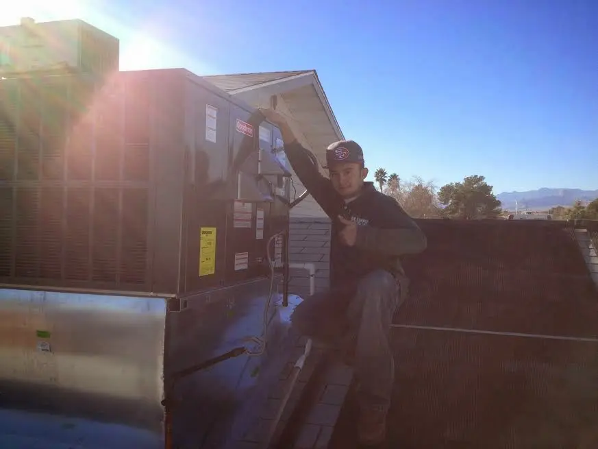 HVAC technician performing AC Tune-Up on a rooftop unit in Wapakoneta